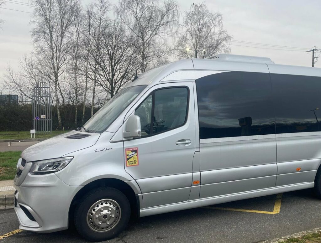 Minibus Mercedes Sprinter avec chauffeur stationne avant un transfert de groupe