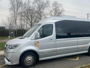 Minibus Mercedes Sprinter avec chauffeur stationne avant un transfert de groupe