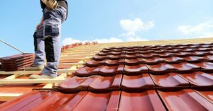 Couvreur posant des tuiles sur une toiture en rénovation