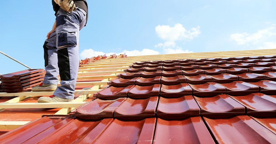 Couvreur posant des tuiles sur une toiture en rénovation