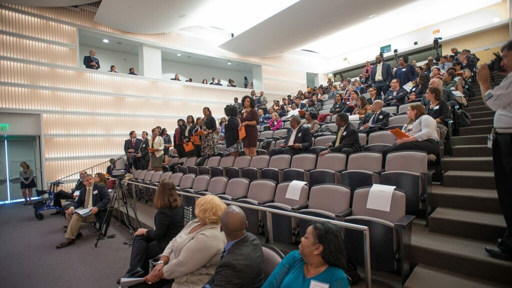 Participants assis dans un amphithéâtre pendant une assemblée